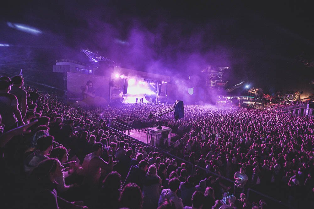 People watching a concert. Photo with a purple hue